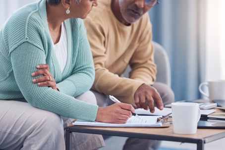 Elderly man and woman signing legal paperwork