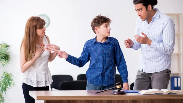 Three individuals engaged in a serious discussion around a desk with legal books and a gavel.