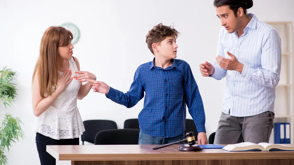 Three individuals engaged in a serious discussion around a desk with legal books and a gavel.